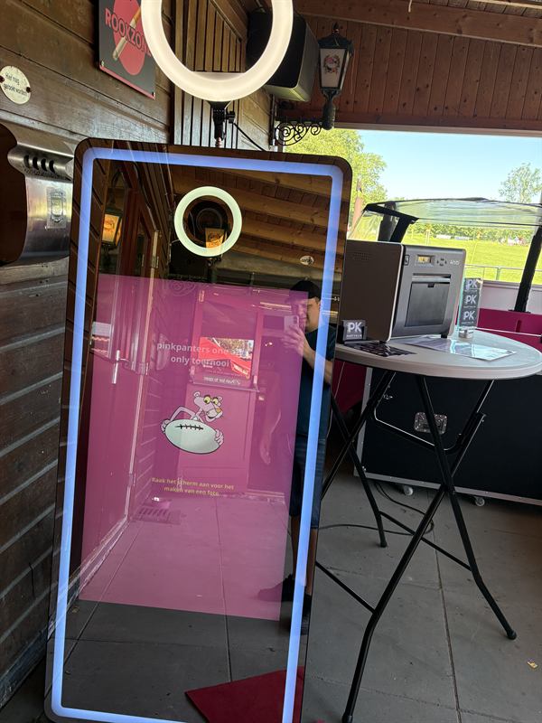 De photobooth buiten opgesteld bij een sporttoernooi, compleet met printer en props-tafel